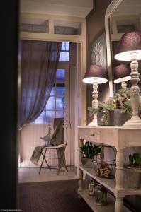 a room with a mirror and a table with plants at Hôtel des Alpes in Annecy