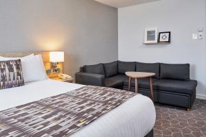 Holiday Inn Ellesmere Port/Cheshire Oaks, an IHG Hotel في إليسمير بورت: غرفه فندقيه بسرير واريكه