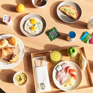 uma mesa com pratos de comida para o pequeno almoço em INNSiDE by Meliá Paris Charles de Gaulle Airport em Roissy-en-France