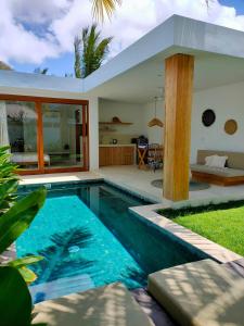 eine Villa mit einem Pool und einem Haus in der Unterkunft Kalea Villas in Kuta Lombok