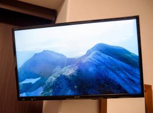 a television screen with a picture of a mountain at Hotel Trend JR Uji Ekimae in Uji