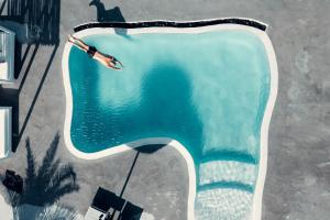 a person swimming in a swimming pool at Villa Beltramo Santorini 2 bedroom private pool villa in Foinikiá