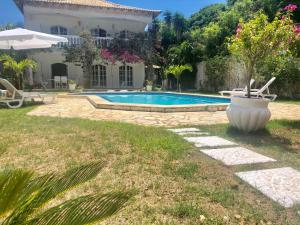 einen Hinterhof mit einem Pool und einem Haus in der Unterkunft Villa Saint Tropez in Cabo Frio