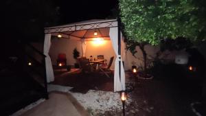 a gazebo with a table and chairs under it at night at Artista B&B in Càbras