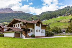 uma casa num campo com montanhas ao fundo em Vizensn Living em Sölden