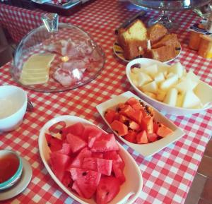 una mesa cubierta con tazones de frutas y otros alimentos en Quinta dos Álamos Agroturismo, en Golegã