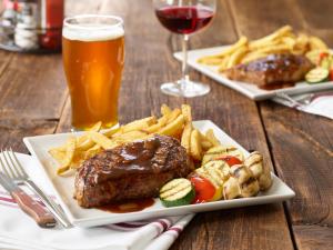 une assiette de viande et de frites et un verre de bière dans l'établissement Holiday Inn Indianapolis Airport, an IHG Hotel, à Indianapolis