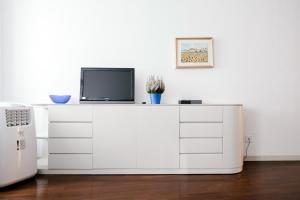 a white cabinet with a tv on top of it at Downtown Como-Porta Torre Flat in Como