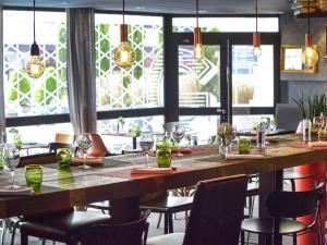 una gran mesa de madera en un restaurante con sillas en Novotel Metz Centre, en Metz