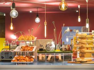 un buffet con pan y bollería y luces colgantes en Novotel Metz Centre, en Metz