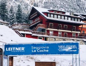 ein Gebäude mit einem Schild davor im Schnee in der Unterkunft Hotel Piccolo Chalet in Claviere