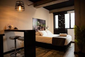 1 dormitorio con cama y mesa con taburete en The Coffee Club Apartahotel, en Manizales