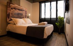 1 dormitorio con 1 cama y ventana grande en The Coffee Club Apartahotel, en Manizales