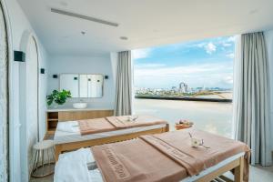 Habitación de hotel con 2 camas y ventana grande. en HAIAN Riverfront Hotel Da Nang, en Da Nang