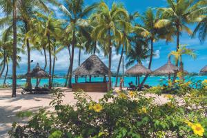 a beach with palm trees and a gazebo at Mauricia Beachcomber Resort & Spa in Grand Baie