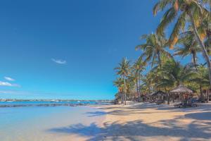 a sandy beach with palm trees and the ocean at Mauricia Beachcomber Resort & Spa in Grand Baie