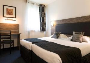 A bed or beds in a room at The Originals City Hôtel, Aéroport Beauvais