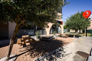 a park with benches and a tree and a stop sign at Hotel Gascogne in Toulouse