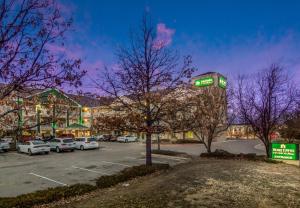 奥罗拉HomeTowne Studios by Red Roof Denver - Airport/Aurora的停车场,有一座带钟楼建筑