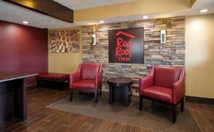 Red Roof Inn Lansing East - MSU في لانسينغ: بار وكراسي حمراء وجدار صخري