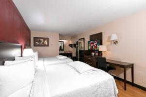 ein Hotelzimmer mit 2 Betten und einem Schreibtisch in der Unterkunft Red Roof Inn PLUS+ Washington DC - Alexandria in Alexandria