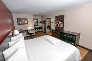 een slaapkamer met een wit bed en een bureau bij Red Roof Inn PLUS+ Washington DC - Oxon Hill in Oxon Hill