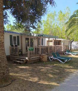 uma casa móvel com um alpendre e 2 espreguiçadeiras em Mobile Homes by KelAir at Playa Montroig Camping Resort em Tarragona