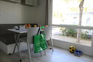 uma sala de jantar com mesa e cadeiras e uma bola de futebol em Mobile Homes by KelAir at Playa Montroig Camping Resort em Tarragona