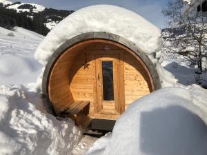 une cabane en bois avec une porte dans la neige dans l'établissement MyApart 1709, à Jochberg