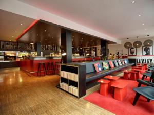 eine Bar mit roten Stühlen in einem Restaurant in der Unterkunft citizenM Glasgow in Glasgow