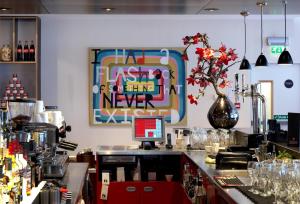 eine Bar in einem Restaurant mit einem Schild an der Wand in der Unterkunft citizenM Glasgow in Glasgow