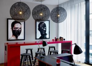 Zimmer mit einer Bar mit Hockern und Hängelampen in der Unterkunft citizenM Glasgow in Glasgow