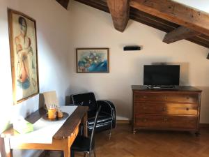 a room with a desk and a tv and a dresser at Residenza Privata Pedrotti in Vicenza