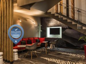 a lobby with a table and chairs and a staircase at ibis Paris Montmartre Sacré-Coeur in Paris