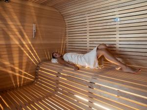 uma mulher deitada numa sauna de madeira em Grand Hotel Costa Brada em Gallipoli