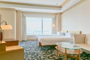 a hotel room with two beds and a couch and a window at Hotel Seagull Tenpozan Osaka in Osaka