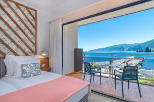 1 Schlafzimmer mit einem Bett und einem Balkon mit Aussicht in der Unterkunft Aqua Natura Bay in Porto Moniz