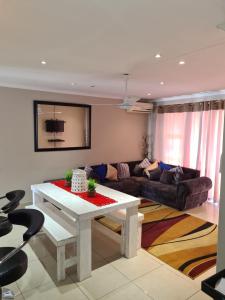 salon ze stołem i kanapą w obiekcie Durban Beach Getaway - Summersands, Inverter for load shedding, free wifi & free Parking w mieście Durban