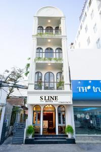 un edificio blanco con un letrero que lee cuarto de brillo en Sline Hotel, en Hue