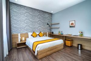 1 dormitorio con cama y pared de ladrillo en Sline Hotel, en Hue