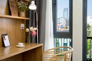 Habitación con escritorio y ventana con silla. en Sline Hotel, en Hue