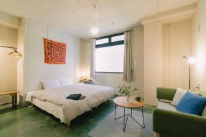 a bedroom with a bed and a table and a couch at Len Kyoto Kawaramachi in Kyoto