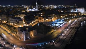 een stad verlicht in de nacht met straatverlichting bij Casa di Fló in Bari