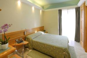 a bedroom with a bed and a table and a window at Hotel Sempione in Milan