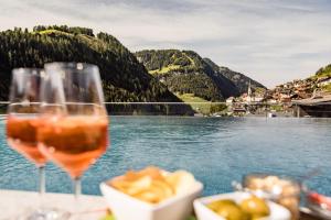 tavolo con bicchieri di vino e vista sul lago di Hotel Touring Dolomites a Santa Cristina in Val Gardena