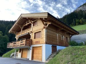 drewniany dom z balkonem na wzgórzu w obiekcie Chalet Soleya w mieście Le Grand-Bornand