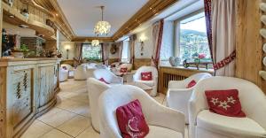 a waiting room with white chairs and a bar at Hotel les Sapins in La Clusaz