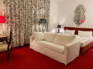 a living room with a white couch and a table at Hotel Deutscher Kaiser in Nürnberg