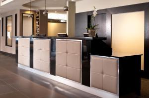 a lobby with a bar with white seats at Leonardo Hotel Dublin Christchurch in Dublin