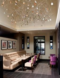 a restaurant with a large chandelier and tables and chairs at Leonardo Hotel Dublin Christchurch in Dublin